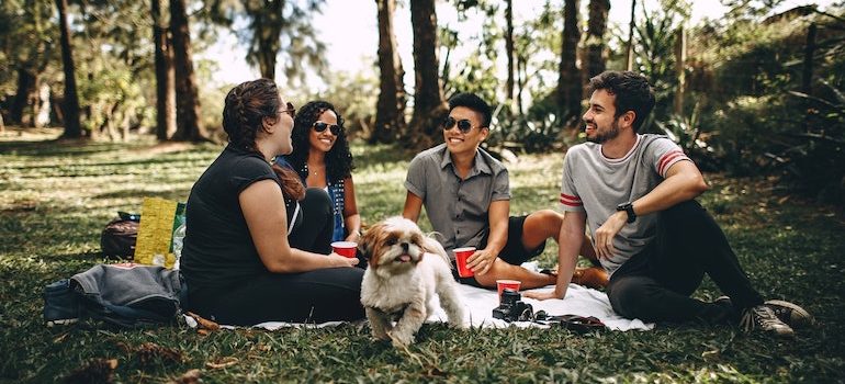 four friends with a dog having a picnic 
