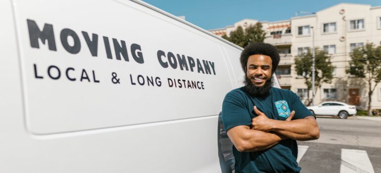 A mover standing in front of the white van; choose moving services you need the most based on the type of your move