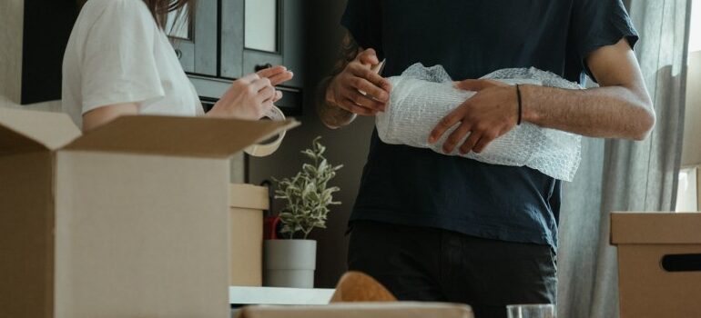 person holding a bundle of bubblewrap, showing what you need for unpacking your household after moving